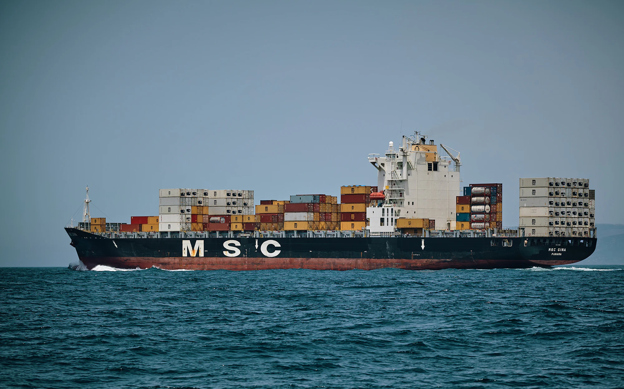 Container vessel under way, carrying bulk raw material consignments