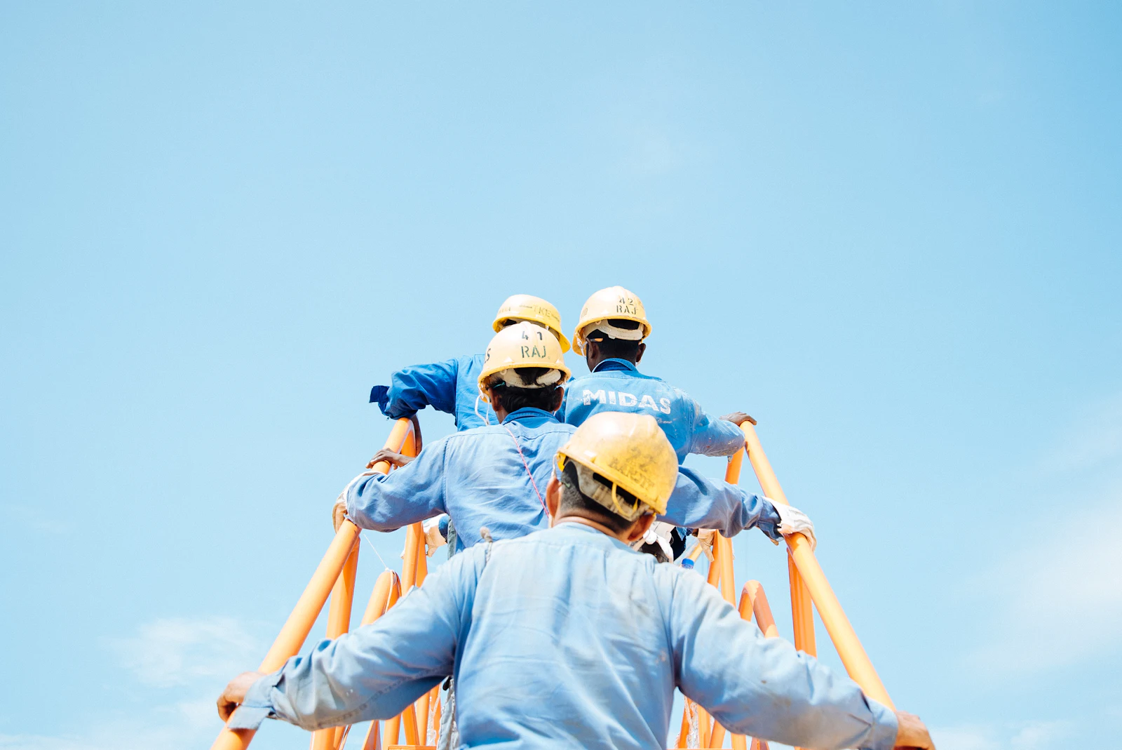 Crew at work on an industrial structure against the sky