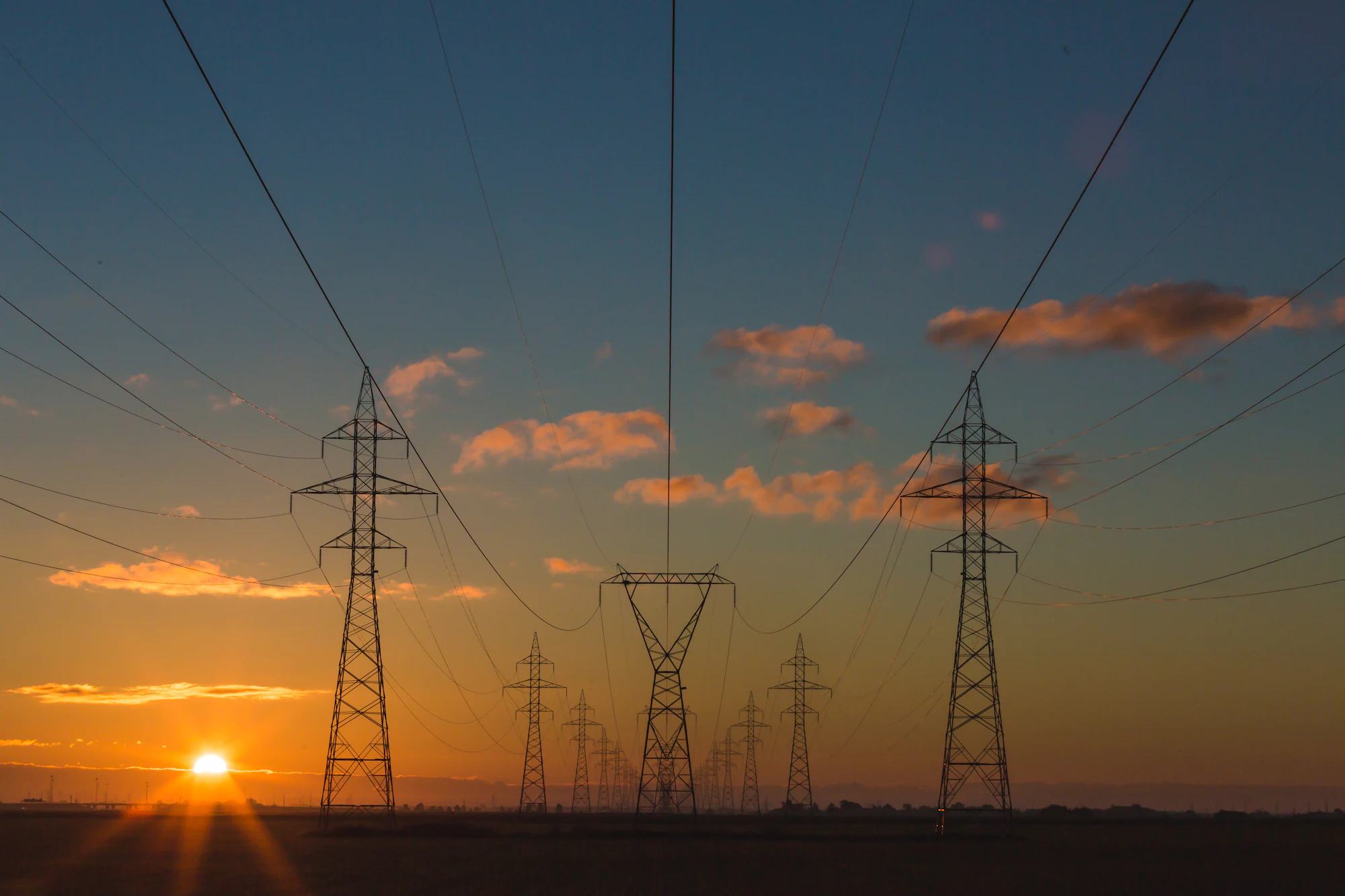 Transmission lines and industrial infrastructure at dusk